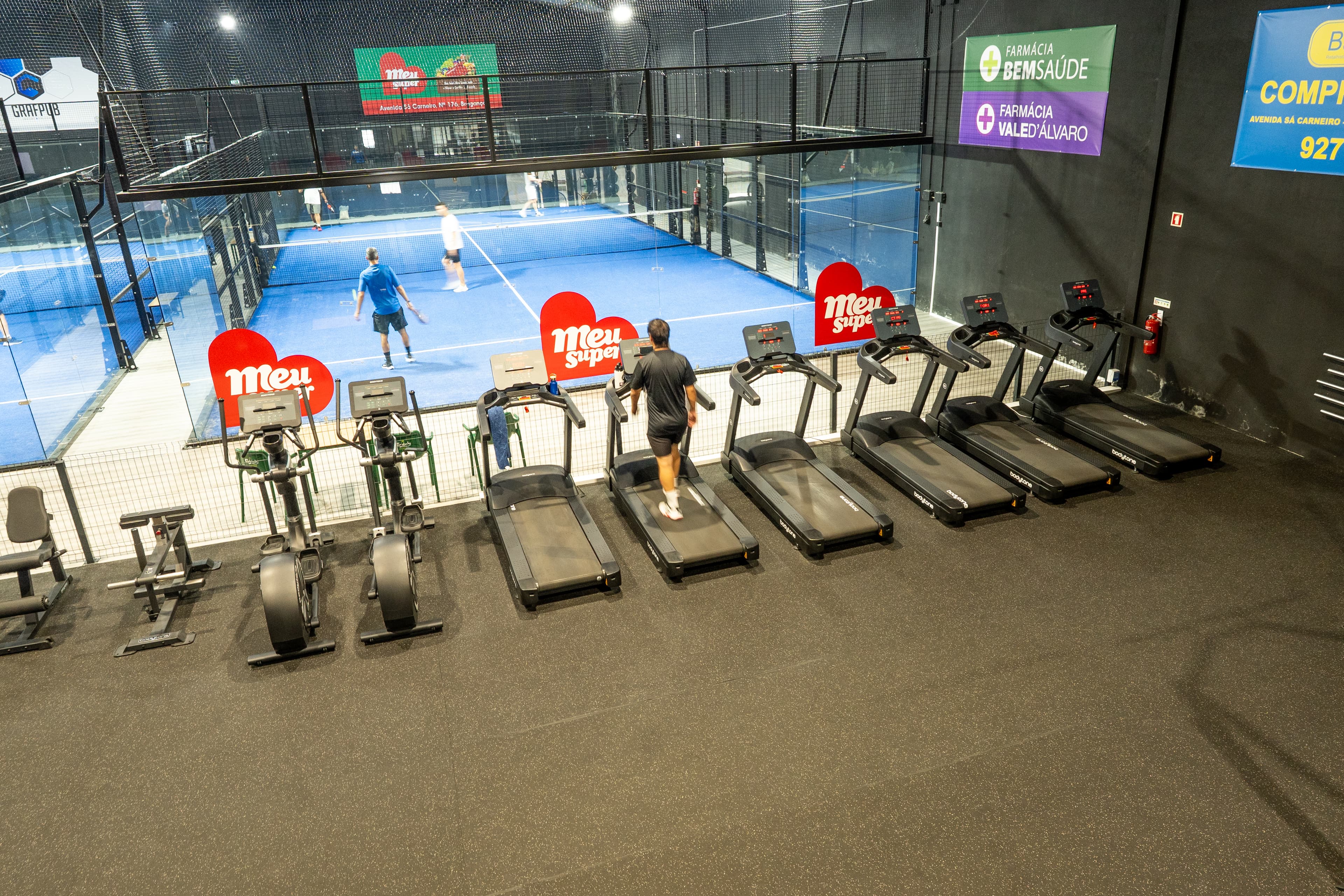 Zona de cardio do Ginásio BLOKO, com vista para os campos de padel